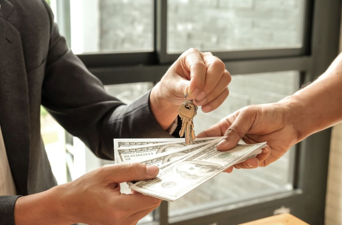 Hands exchanging money for keys.