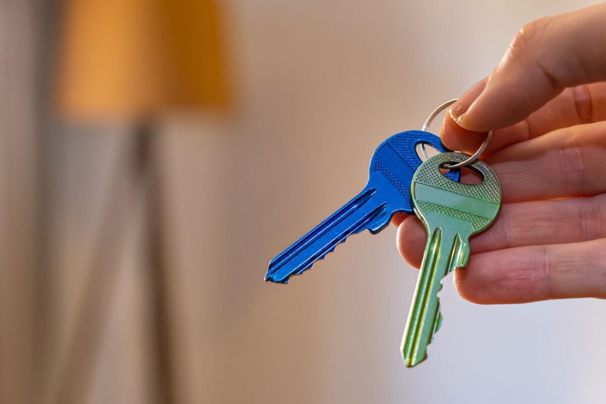 An individual holding a pair of keys.